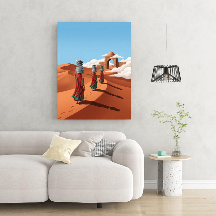 Wadi Home Desert Journey Wall Art: Three women in red and green saris walk across sand dunes carrying stacks of items on their heads. Archway in background.