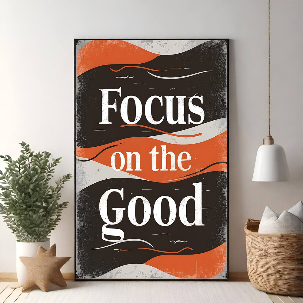 Wadi Home motivational wall art with bold white typography reading "Focus on the Good" on a distressed black background with retro orange wave accents.