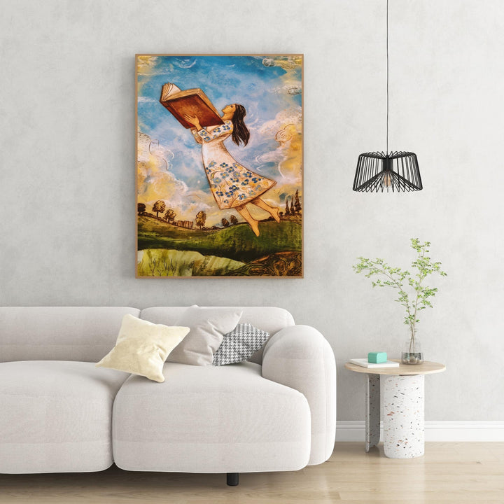 Wadi Home wall art: girl in white floral dress flying with open book, whimsical clouds and landscape.