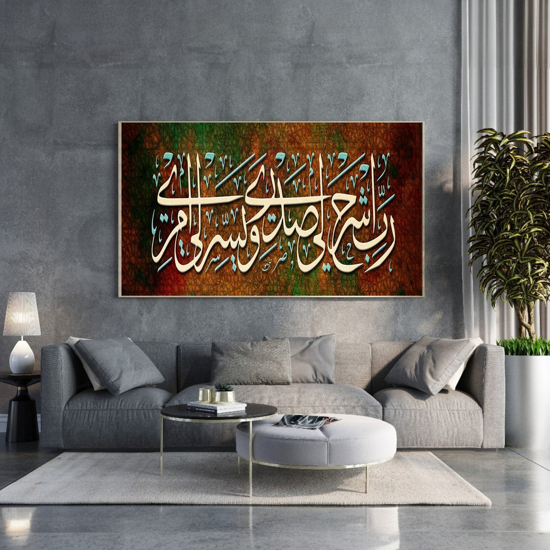 Wadi Home Islamic calligraphy wall art with Arabic script on a textured brown, green, and red background. Framed artwork above a grey sofa.
