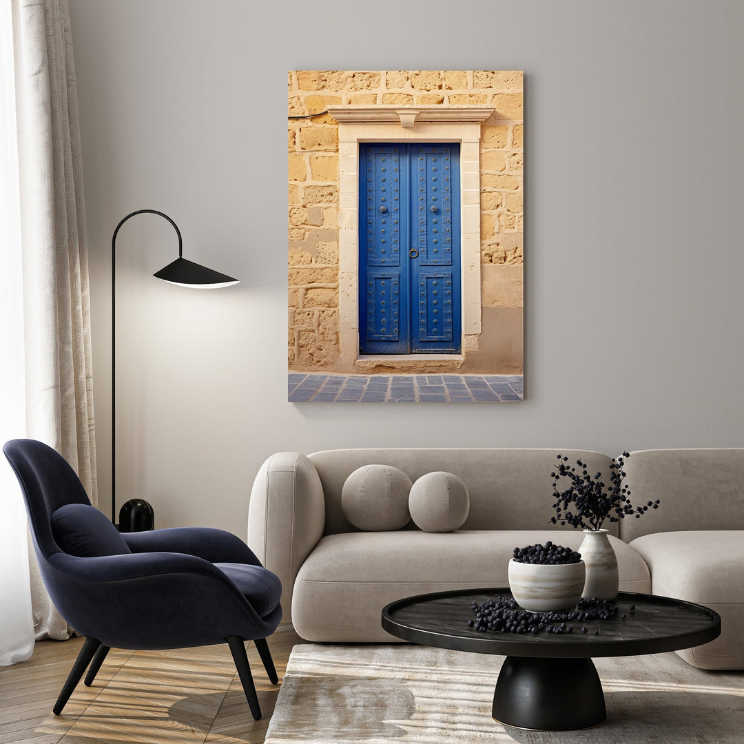 Wadi Home Mediterranean blue door wall art with rustic stone wall and decorative hardware.