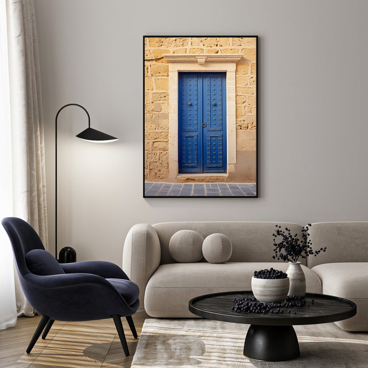 Wadi Home Mediterranean Blue Door wall art featuring a vibrant blue door with decorative hardware against a rustic stone wall.