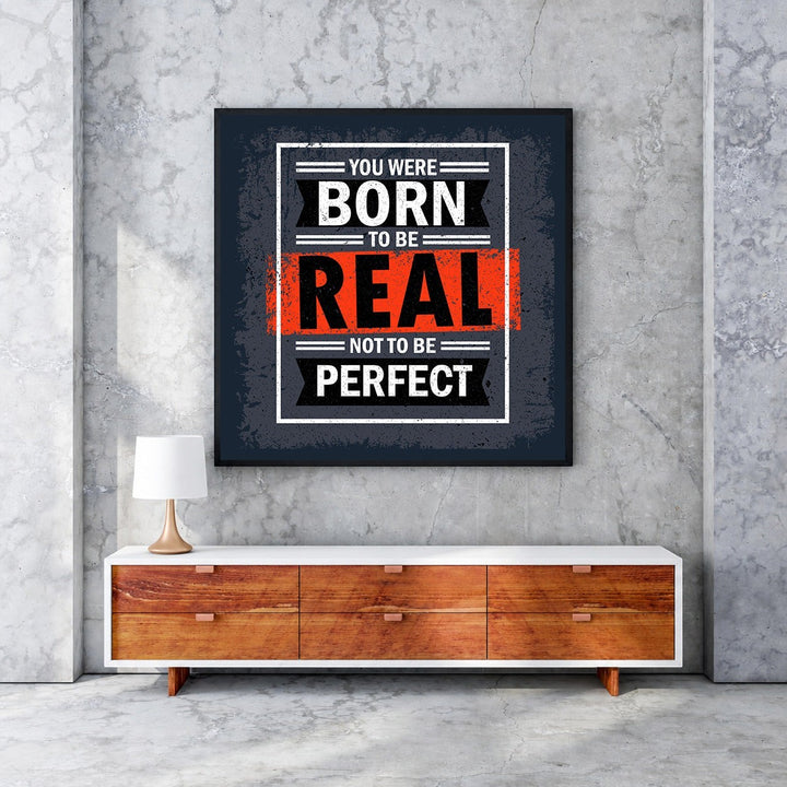Wadi Home motivational wall art with bold text "You Were Born To Be Real Not To Be Perfect" in black, white, and red.