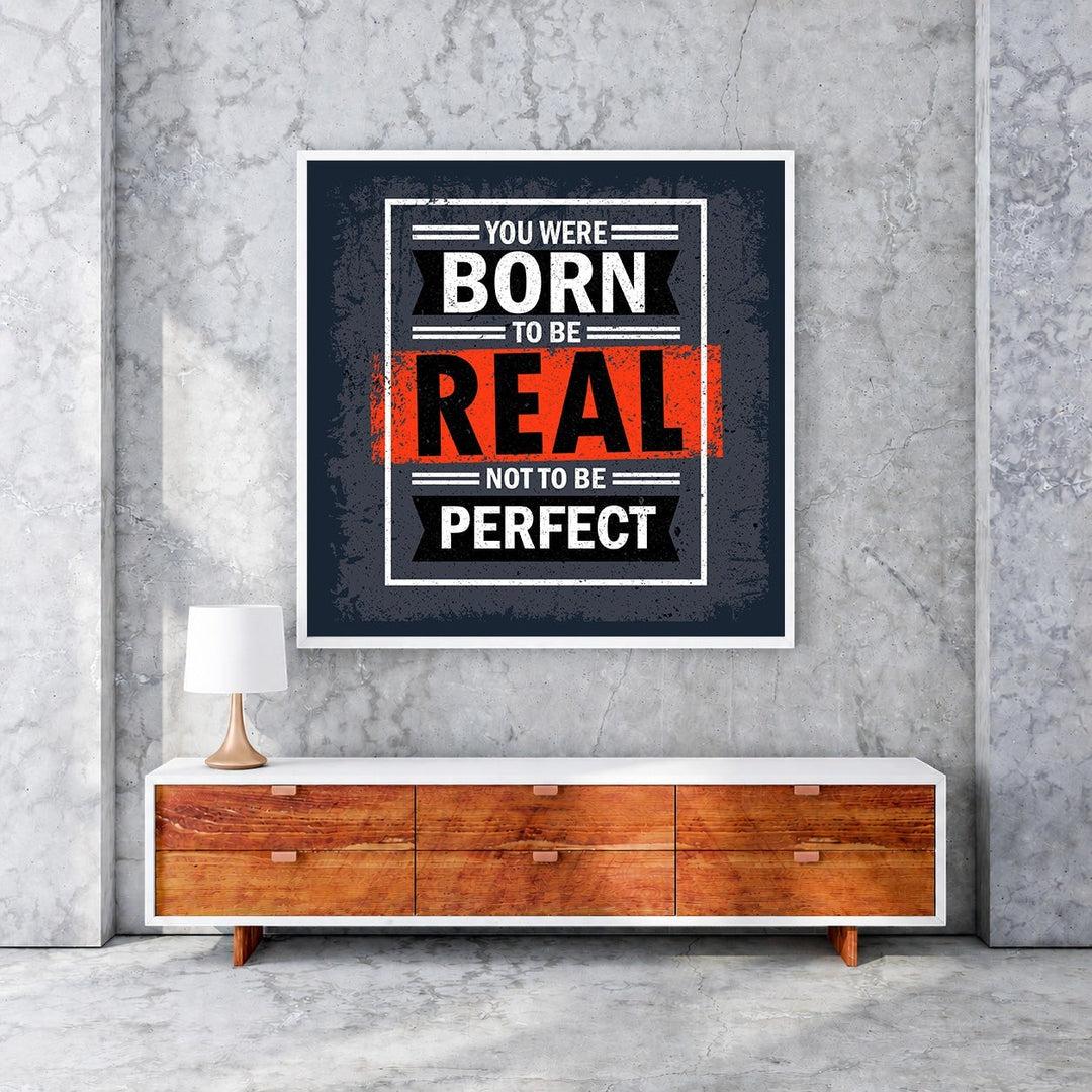 Wadi Home motivational wall art with bold text 'You Were Born To Be Real Not To Be Perfect' in black, white, and orange.