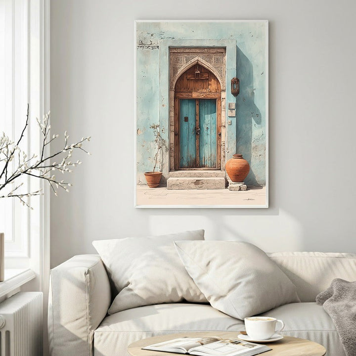 Wadi Home Ornate archway with distressed blue double doors, terracotta pots, and intricate carvings on a textured light blue wall.