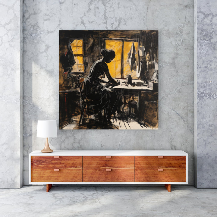 Wadi Home The Seamstress At Work wall art, sketch-style silhouette of a woman sewing at a table, warm yellow window light.
