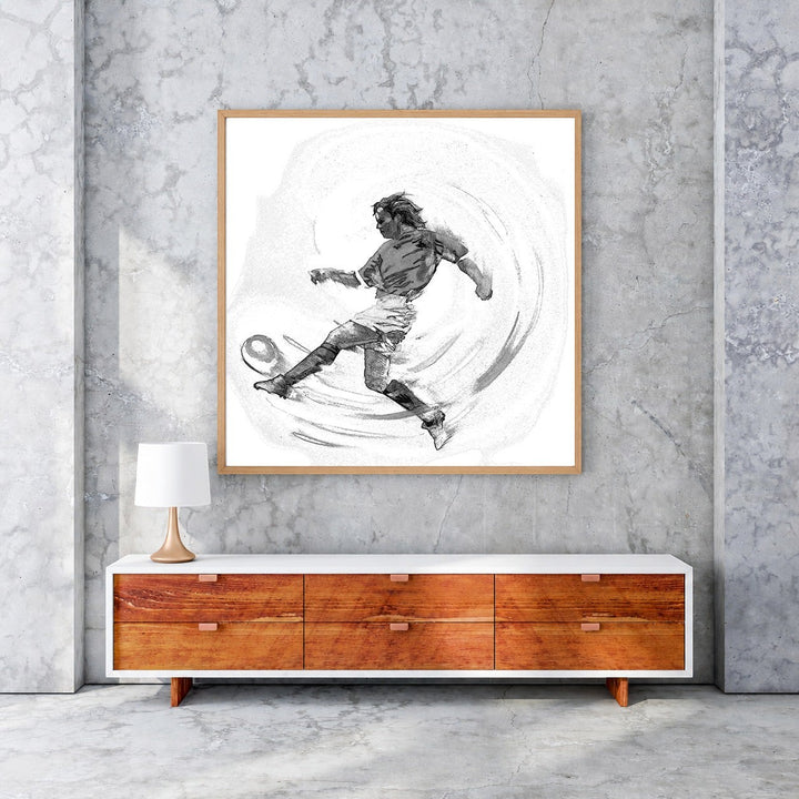 Wadi Home black and white sketch artwork of a soccer player in mid-kick, framed in wood. Dynamic action art.