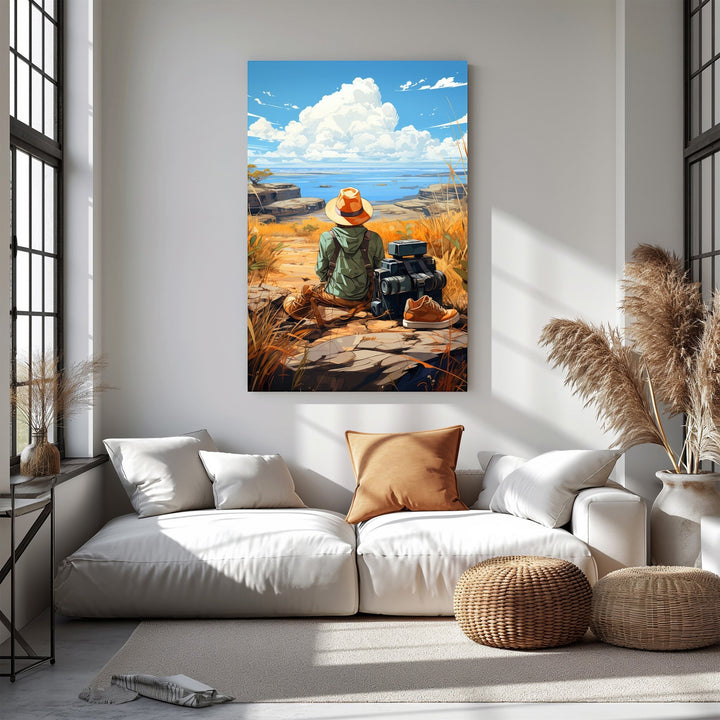 Wadi Home artwork: Traveler in straw hat and green jacket sits on rocks, gazing at ocean horizon. Luggage and boots nearby.