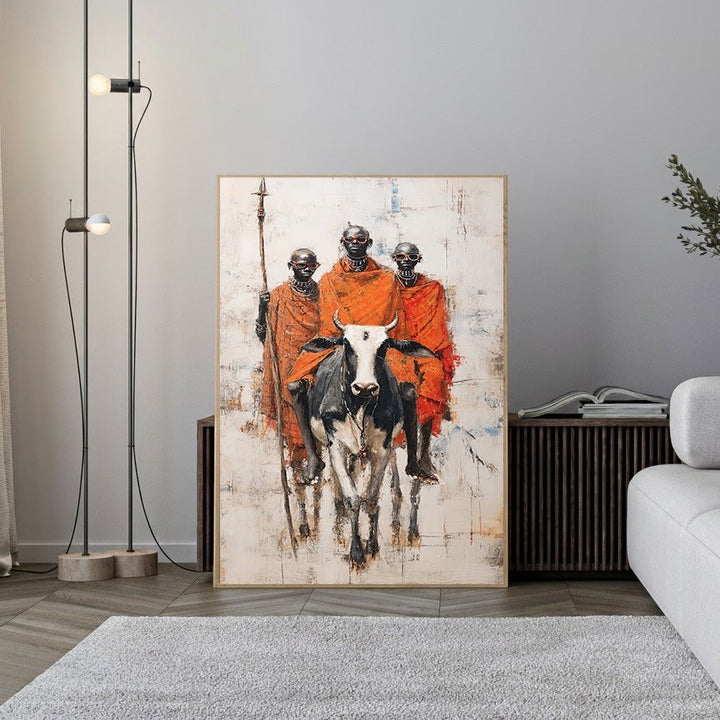 Wadi Home tribal warriors with cattle wall art, featuring three Maasai warriors in orange robes and a black and white cow.