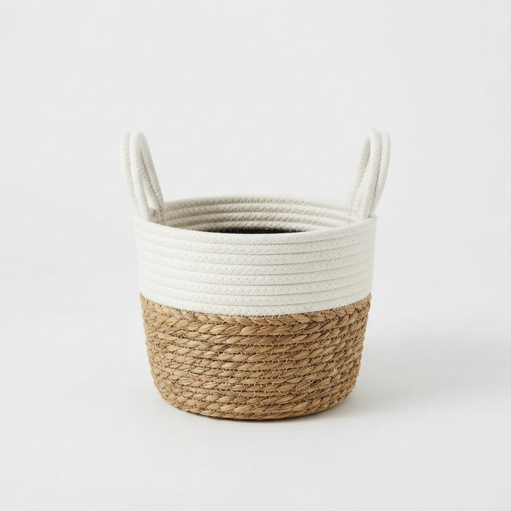 White and natural jute basket planter with white rope handles on a plain white studio background.